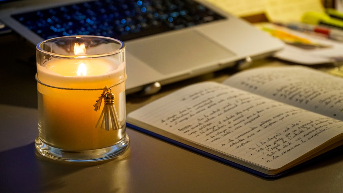 A warm candle-lit study desk with handwritten notes, capturing a calm and focused late-night study session in a cozy home.